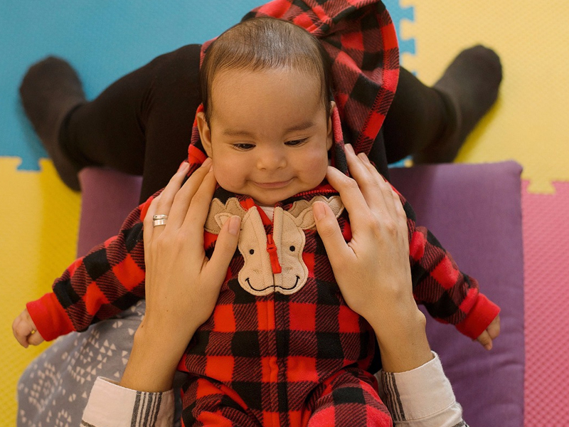 Imagen de una mujer embarazada sentada en el suelo: Mujer embarazada sentada en el suelo con una mano en su vientre, simbolizando la preparación y conexión emocional durante el embarazo.