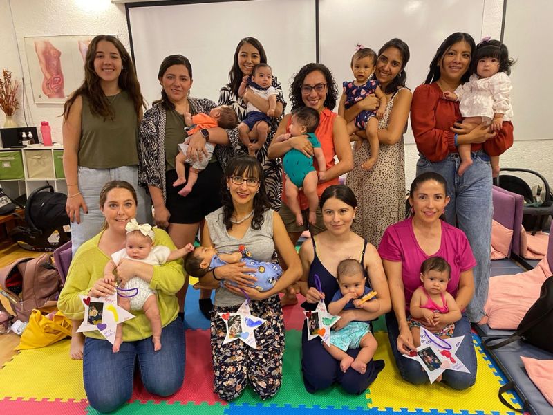 Imagen de una pareja sonriente durante el curso prenatal: Pareja sonriente participando en el curso psicoprofiláctico, mostrando la importancia del apoyo mutuo y la preparación conjunta para el parto.