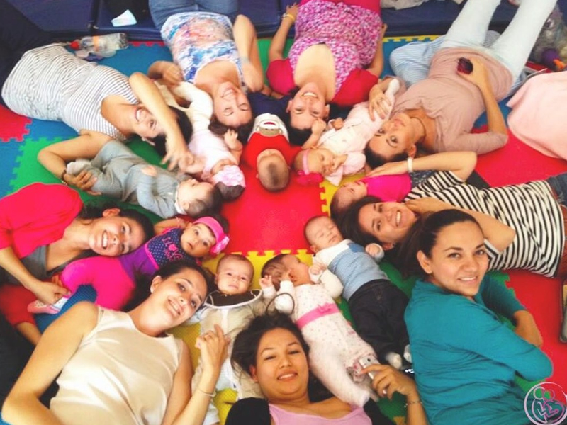 Imagen de futuros padres en una actividad de pareja con los ojos vendados: Futuros padres realizando una actividad de confianza y colaboración con los ojos vendados, parte del curso prenatal psicoprofiláctico.