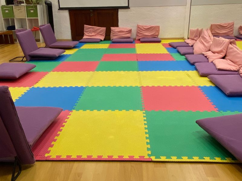 Imagen de un bebé sonriente con un gran lazo en la cabeza: Bebé sonriente con un gran lazo blanco en la cabeza, representando la alegría y el resultado positivo de una preparación adecuada para el nacimiento.