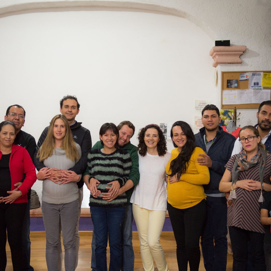 Imagen de futuros padres en una actividad de pareja con los ojos vendados: Futuros padres realizando una actividad de confianza y colaboración con los ojos vendados, parte del curso prenatal psicoprofiláctico.