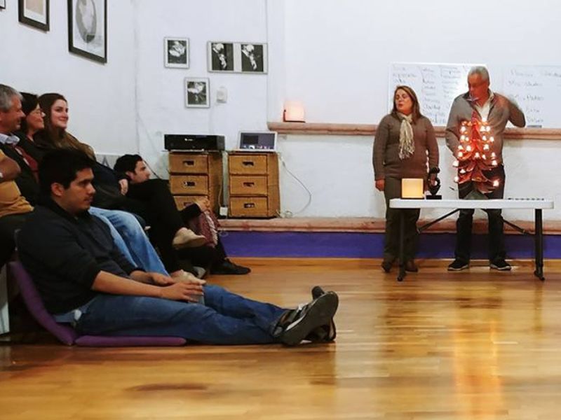 Imagen de una mujer embarazada sentada en el suelo: Mujer embarazada sentada en el suelo con una mano en su vientre, simbolizando la preparación y conexión emocional durante el embarazo.