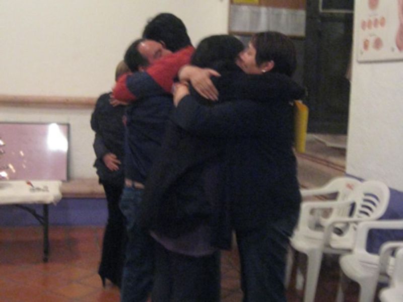 Imagen de una pareja sonriente durante el curso prenatal: Pareja sonriente participando en el curso psicoprofiláctico, mostrando la importancia del apoyo mutuo y la preparación conjunta para el parto.