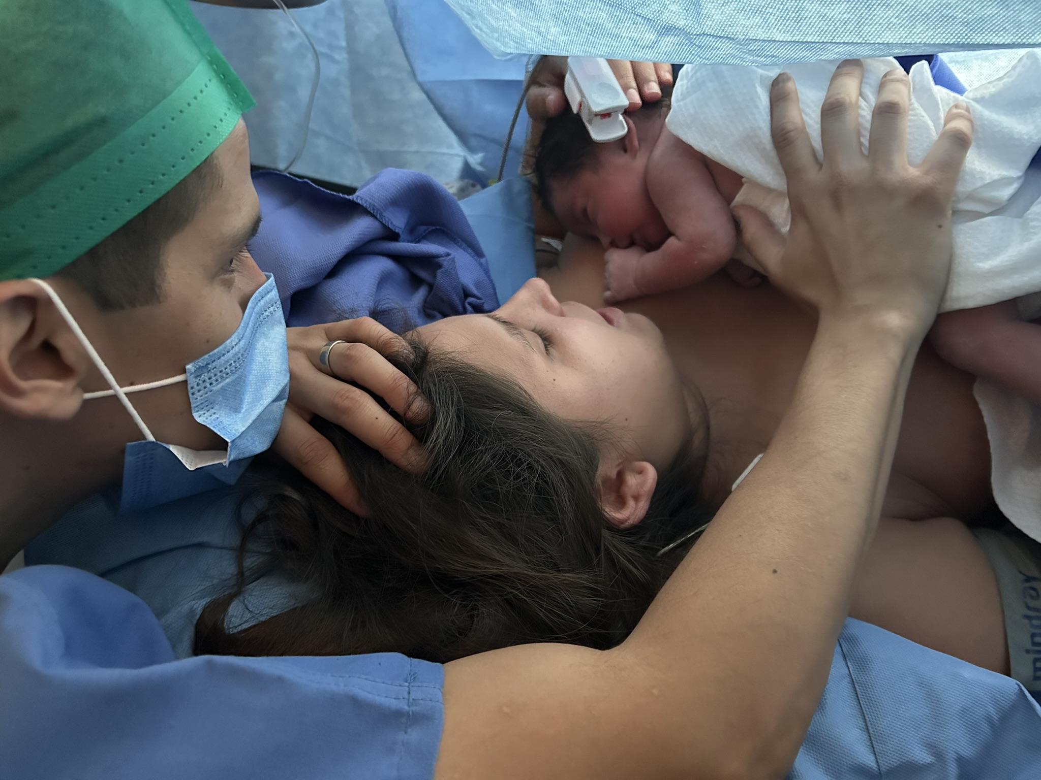 Imagen de un bebé sonriente con un gran lazo en la cabeza: Bebé sonriente con un gran lazo blanco en la cabeza, representando la alegría y el resultado positivo de una preparación adecuada para el nacimiento.