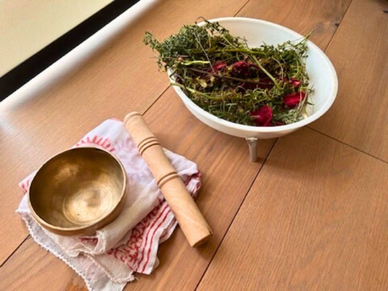 Imagen de una mujer embarazada sentada en el suelo: Mujer embarazada sentada en el suelo con una mano en su vientre, simbolizando la preparación y conexión emocional durante el embarazo.